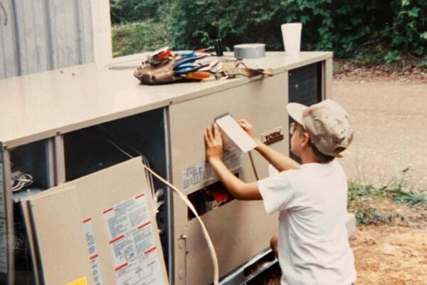 Jay Lovett working on an HVAC unit as a boy